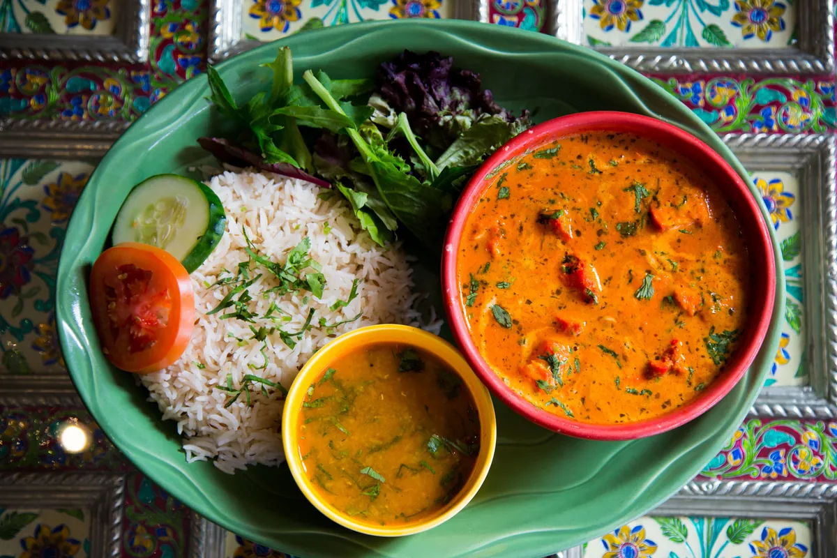 Curry, rice and dal on a green plate at Karma Kafe Indian bistro in Hoboken, NJ