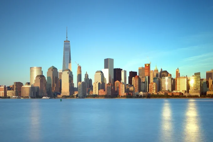 Lower Manhattan skyline glowing at golden hour across the water from Liberty State Park